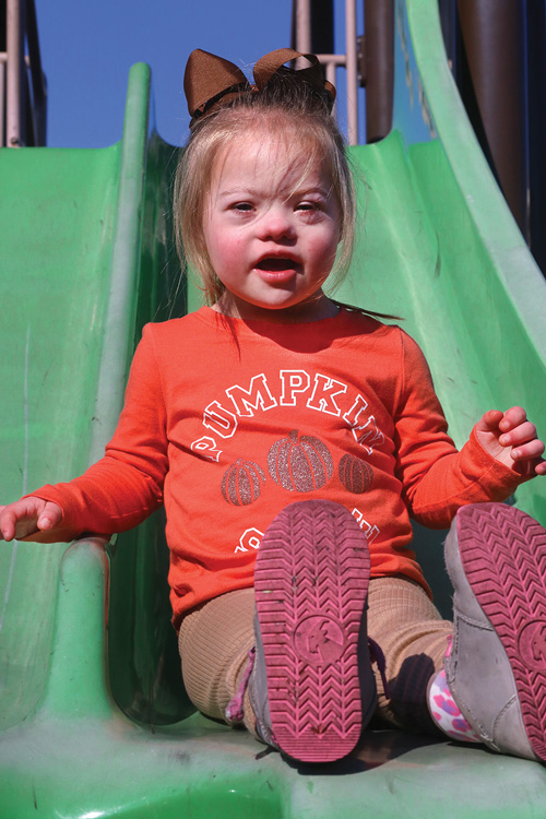 Little girl on a green slide