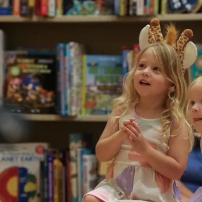 Two sister listening to Debra read Giraffes in my Closet book
