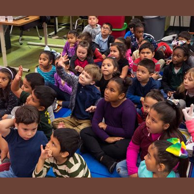 Kids raise their hands to share ideas about giraffes, authors and illustrators.