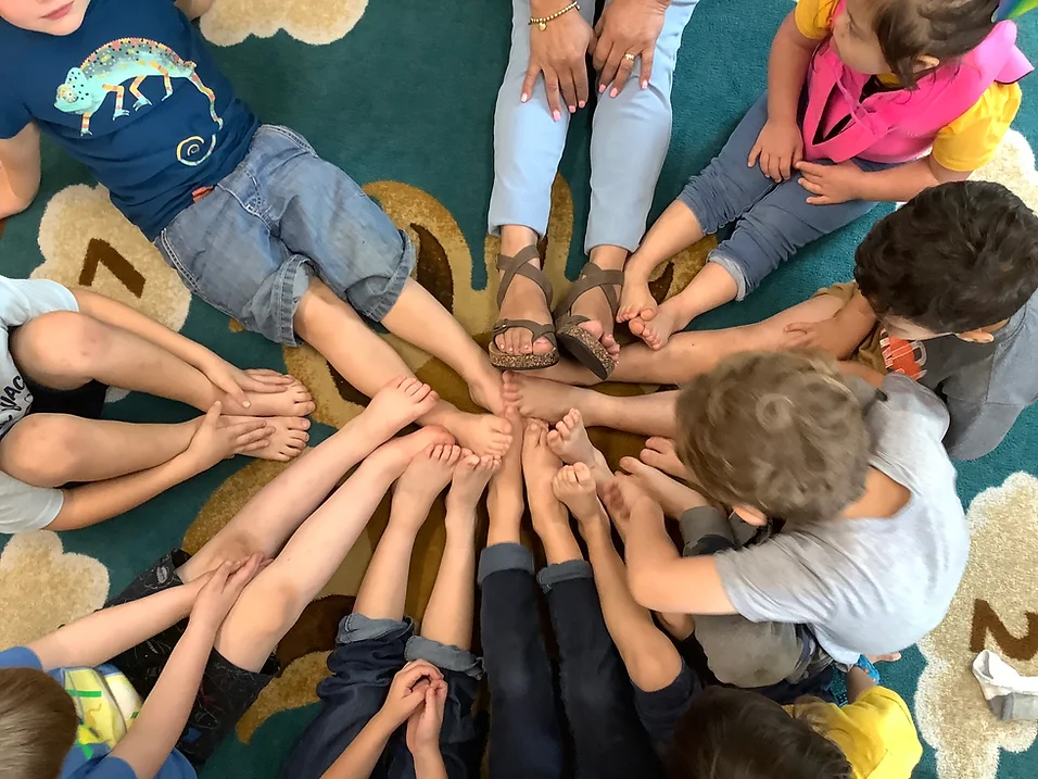 Children sitting in a circle with their feet extended
