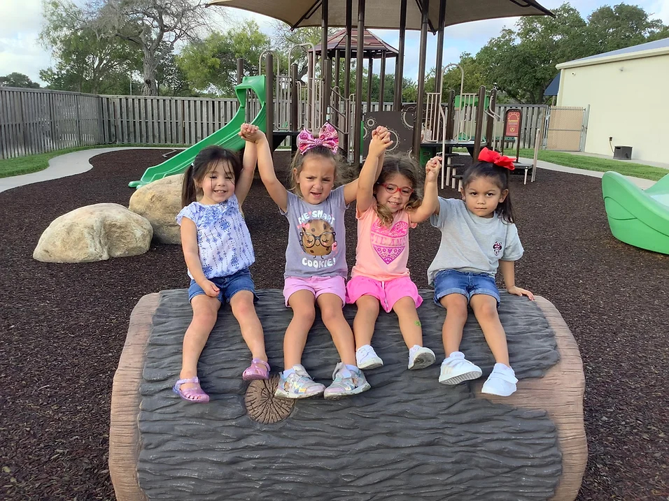 Little girls with their hands up on a playground